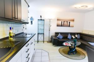 eine Küche und ein Wohnzimmer mit einem Sofa und einem Tisch in der Unterkunft Haus Stranddüne DS29 in Cuxhaven