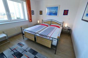 a bedroom with a bed with two red pillows at Haus Nordseebrandung NB36 in Cuxhaven