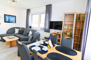 uma sala de estar com uma mesa e um sofá em Haus Seewind HS01 em Cuxhaven