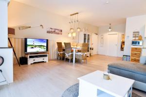 uma sala de estar com um sofá, uma mesa e uma televisão em Haus Frauenpreiss F490 em Cuxhaven
