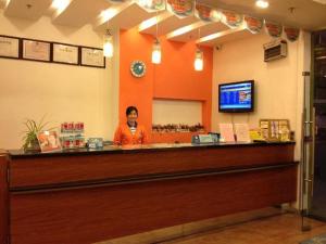 7Days Inn Xiamen Jinshang branch في شيامن: رجل يقف خلف كونتر في مطعم
