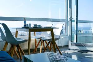 een tafel en stoelen in een kamer met een groot raam bij Haus Frische Brise 0707 in Cuxhaven