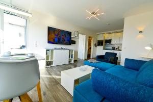 een woonkamer met een blauwe bank en een tafel bij Haus Frische Brise 0707 in Cuxhaven