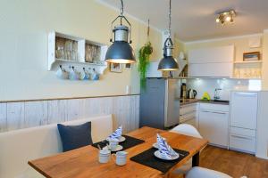 uma cozinha e sala de jantar com uma mesa de madeira com cadeiras em Haus Frische Brise 1210 em Cuxhaven