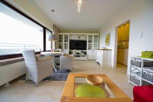 a living room with a table and a television at Strandhochhaus SD06 in Cuxhaven