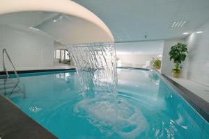 a pool with a water fountain in a building at Strandhochhaus SD06 in Cuxhaven
