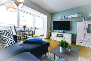 a living room with a couch and a tv at Strandhochhaus SHC2 in Cuxhaven
