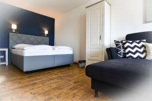 ein Schlafzimmer mit einem Bett und einem Sofa darin in der Unterkunft Strandhochhaus SHC2 in Cuxhaven