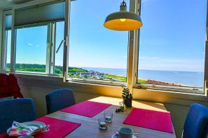 a dining room with a table with a view of the ocean at Strandhochhaus SD09 in Cuxhaven