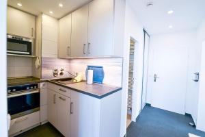 a kitchen with white cabinets and a counter top at Strandhochhaus SD09 in Cuxhaven