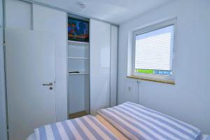 a small bedroom with a bed and a window at Strandhochhaus SD09 in Cuxhaven +18 photos