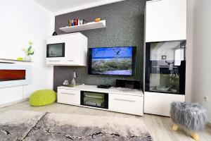 a living room with a white entertainment center with a tv at Strandhochhaus SF10 in Cuxhaven