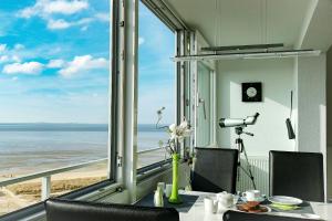 a dining table with a view of the ocean at Strandhochhaus SF10 in Cuxhaven