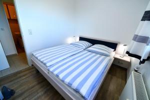 een blauw en wit bed met 2 kussens erop bij Strandhochhaus SF11 in Cuxhaven +16 foto's