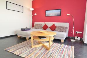 ein Wohnzimmer mit einem weißen Sofa und einem Tisch in der Unterkunft Strandhochhaus SD12 in Cuxhaven