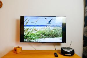 einen Flachbild-TV, der an einer Wand hängt in der Unterkunft Haus Horizont HZ13 in Cuxhaven