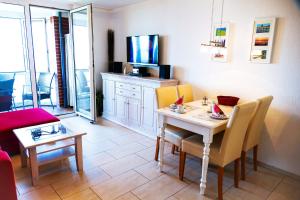 ein Wohnzimmer mit einem Tisch mit Stühlen und einem TV in der Unterkunft Haus Horizont HZ09 in Cuxhaven