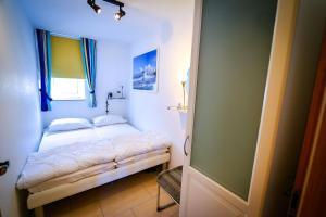 a small bedroom with a bed and a window at Haus Horizont HZ09 in Cuxhaven