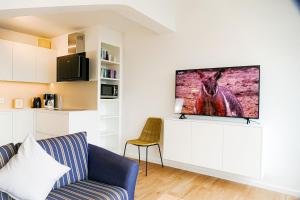 ein Wohnzimmer mit einem Sofa und einem TV an der Wand in der Unterkunft Haus Nordseebrandung NB72 in Cuxhaven