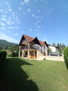 een huis met een groen gazon ervoor bij Apartman Milekic in Mrkonjić Grad