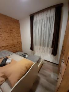 1 dormitorio con cama y ventana en Apartman Milekic, en Mrkonjić Grad