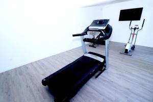 Zimmer mit einem Fitnessraum mit Laufband und Stuhl in der Unterkunft Le Domaine des Gallois in Cornant