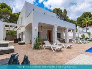 a white house with white furniture and a pool at Villa Milana by HMR Holidays in Moraira