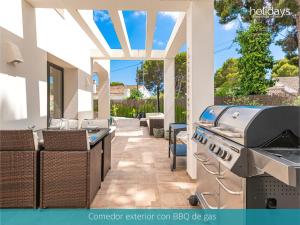 a outdoor patio with a grill and a bar at Villa Milana by HMR Holidays in Moraira