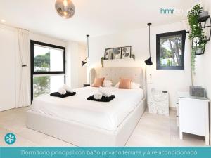 a bedroom with a large white bed with two hats on it at Villa Milana by HMR Holidays in Moraira +34 photos