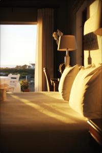 a bedroom with a bed with a window and a lamp at Klokkiebosch Guesthouse in Jacobs Bay