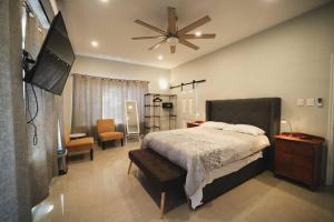 a bedroom with a bed and a ceiling fan at The Ansen Place in Belmopan