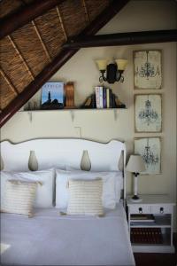 a bedroom with a white bed with two pillows at Klokkiebosch Guesthouse in Jacobs Bay