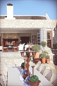 d'une terrasse avec une table, des chaises et une cheminée. dans l'établissement Klokkiebosch Guesthouse, à Jacobs Bay