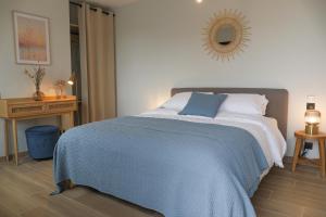 a bedroom with a bed with a blue blanket on it at La Maison des Embruns in Plouarzel +46 photos