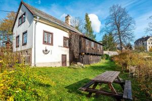 una mesa de picnic frente a un edificio antiguo en Čertův mlýn - pohádková chalupa - Jizerské hory en Bílý Potok