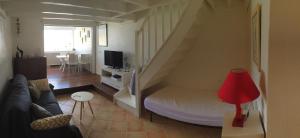 a living room with a couch and a tv at Entre Ciel Et Mer in Saint-François