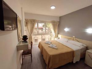 um quarto de hotel com uma cama e uma janela em ADM Ayamitre Hotel em Buenos Aires