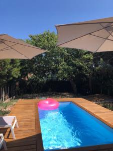 - un frisbee dans une piscine avec un parasol dans l'établissement Biby BeachHouse, à Lacanau