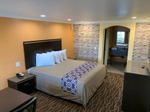 a hotel room with a large bed and a bathroom at Industry Inn & Suites in La Puente