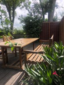 una mesa de picnic de madera y sillas en una terraza en Luxe vrijstaande chalet voor gezinnen en stellen, en Elahuizen