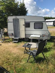 an rv with a table and a chair at Caravan Petiet in Buren