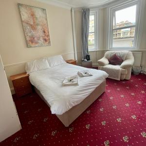 Habitación de hotel con cama y silla en THE LODGE BOURNEMOUTH, en Bournemouth