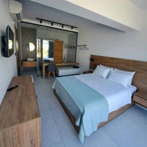 a large bedroom with a large bed and a desk at Courtyard Luxury Suites “ APOSTOLOS” in Pefki