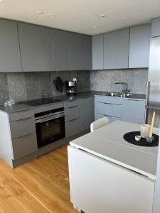 uma cozinha com armários brancos e um balcão branco em Elme apartment em Växjö