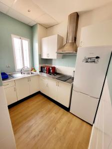 a kitchen with white cabinets and a white refrigerator at Sunlight Málaga Centro in Málaga