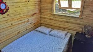 um quarto com uma cama num chalé de madeira em Guanaja Backpackers Hostel em Guanaja