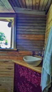 a bathroom with a sink on a wooden wall at Guanaja Backpackers Hostel in Guanaja