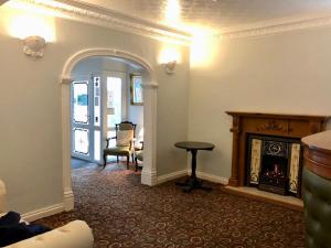 a living room with a fireplace and a chair at Bryn Noddfa in Morfa Nefyn