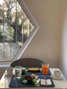 ein Tisch mit Essen und Getränken auf einem Tisch mit Fenster in der Unterkunft Abitatt Apart-Suite in Fosdinovo