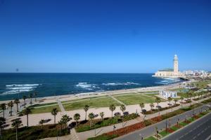 a view of the beach and the ocean with a lighthouse at Appartement Casablanca in Casablanca
